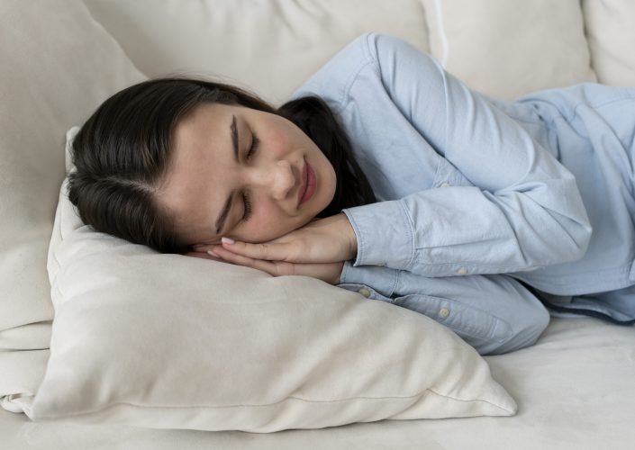 medium-shot-woman-sleeping-couch